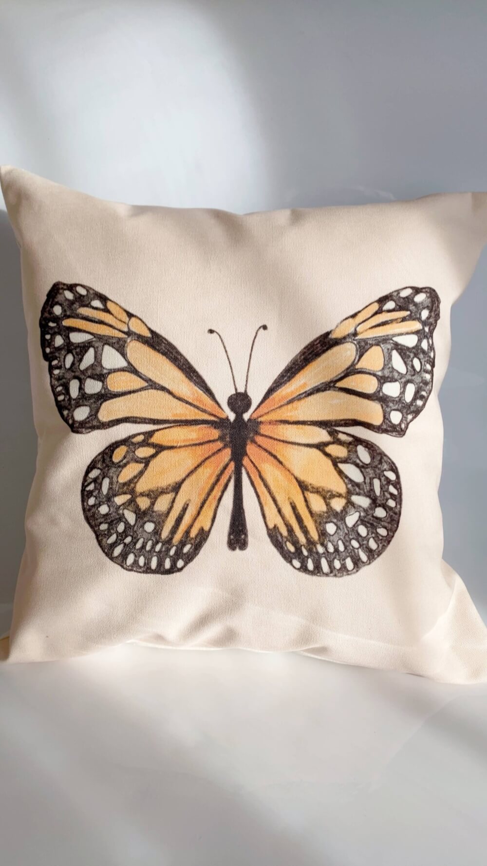 coussin rose pâle en toile de coton avec motif papillon Monarch