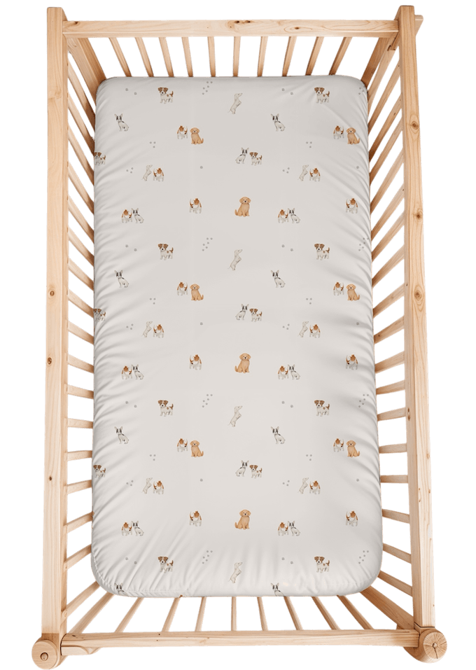 Le drap est orné d'un imprimé délicat mettant en vedette une "équipe" de petits chiens de races différentes. On peut y apercevoir des illustrations de chiots aux tons naturels (marron, beige, blanc et noir), notamment des bouledogues français, des goldens retrievers ou labradors, et d'autres petits chiens à taches.