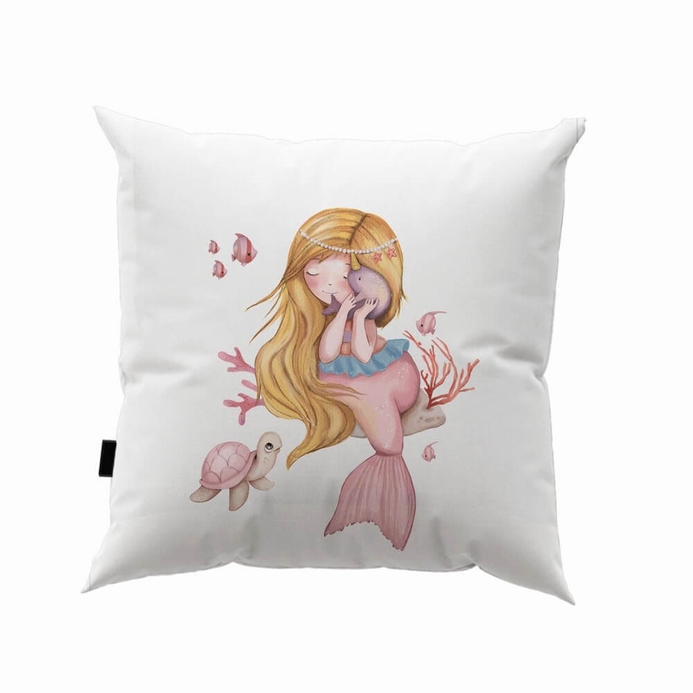 la housse de coussin Sirène rose en coton présente un motif charmant où une sirène blonde caresse délicatement un poisson.