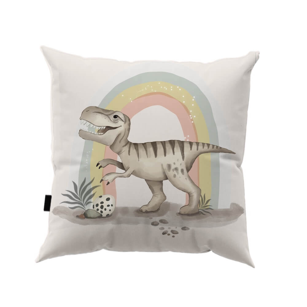 housse de coussin avec motif imprimé un petit dinosaure t -rex qui a l'air presque gentil sous son arc-en-ciel pastel, avec un œuf caché dans les feuillages.